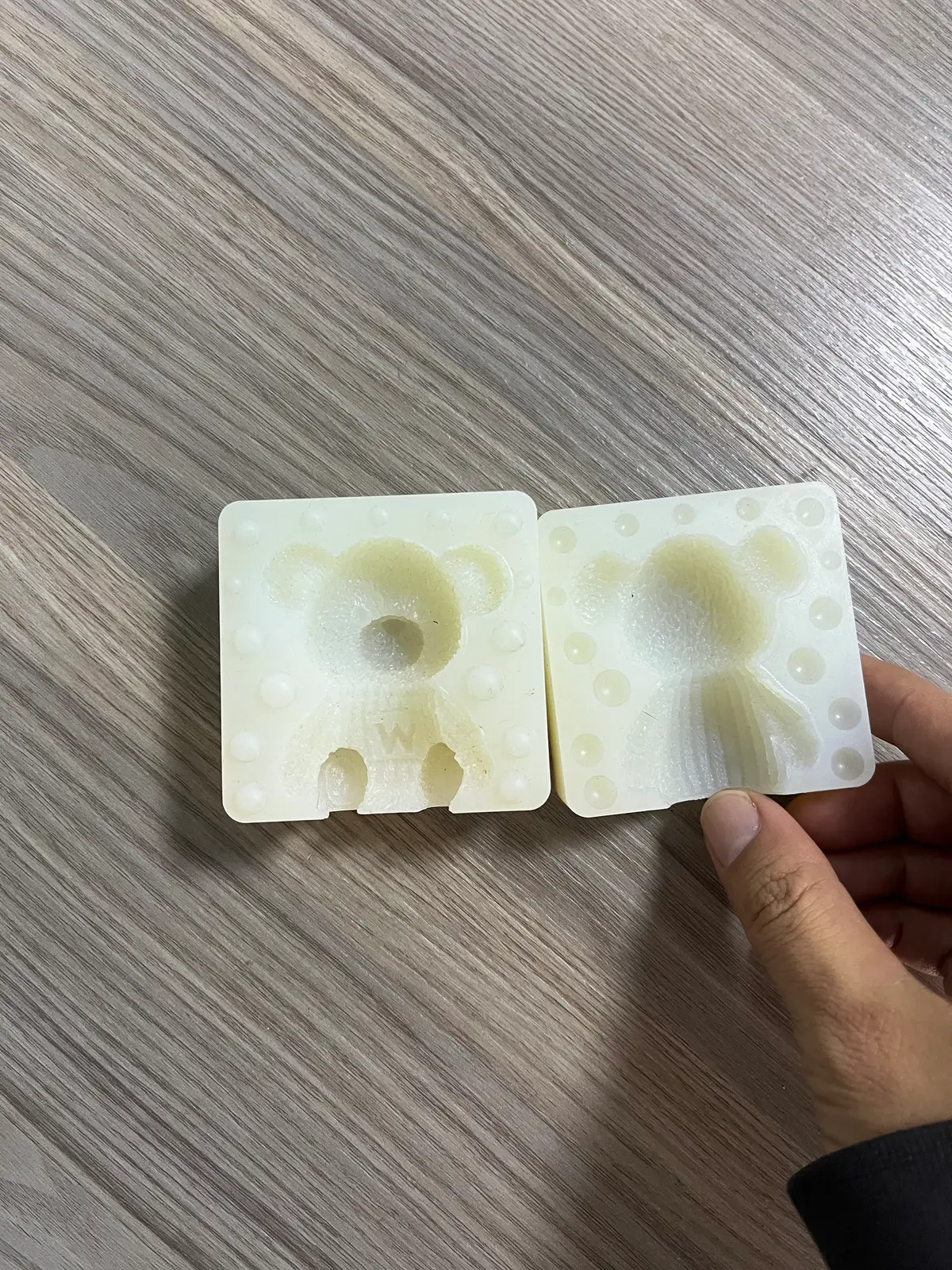 Two-part silicone figurine mold, front and back halves on a bench